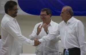 Handschlag nach Unterzeichnung des Abkommens: Die Leiter der Friedensdelegationen der Farc, Iván Marquez (links), und der Regierung, Humberto de la Calle (rechts). Beifall von Kubas Außenminister Bruno Rodríguez Parilla (hinten im Bild) / Foto: Ladyrene Pérez/Cubadebate