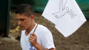 Ein ehemaliger FARC-Kämpfer mit einer Friedensfahne. Bald ein Bild der Vergangenheit? Foto: Colombia Informa