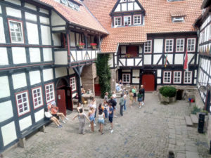 Freiwillige stehen im Hof der Burg Ludwigstein vor Fachwerkhäusern.