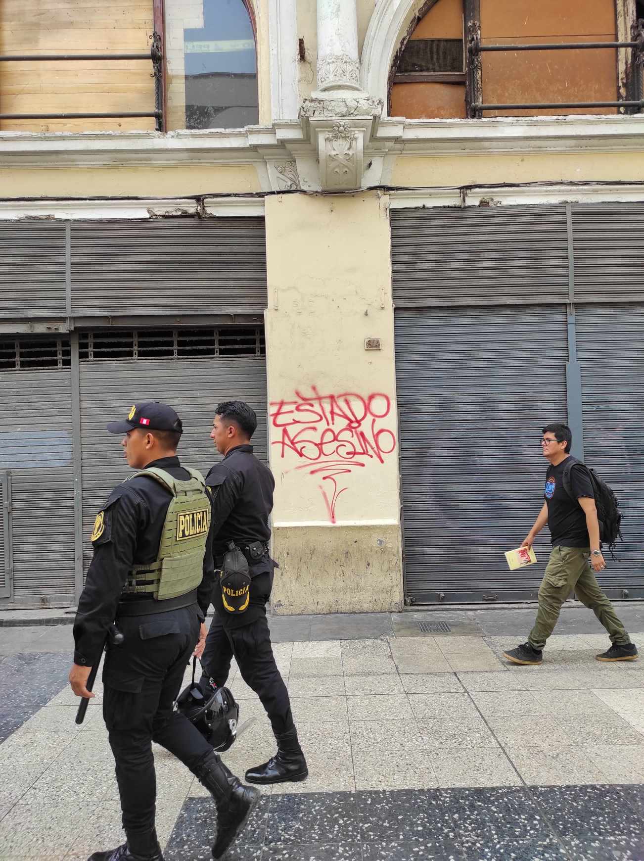Sicherheitskräfte und ein Passant vor dem Grafitti:
"Mörderstaat!"
Foto: Aliza Yanes