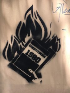 Ein Graffity aus Santiago de Chile zeigt eine brennende Verfassung von 1980