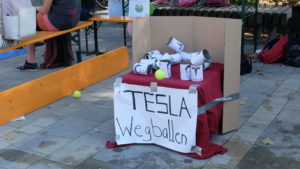 "Echar a Tesla", en un juego niños se tiran pelotas a tarros con símbolos de Muskfotos de Elon Musk.